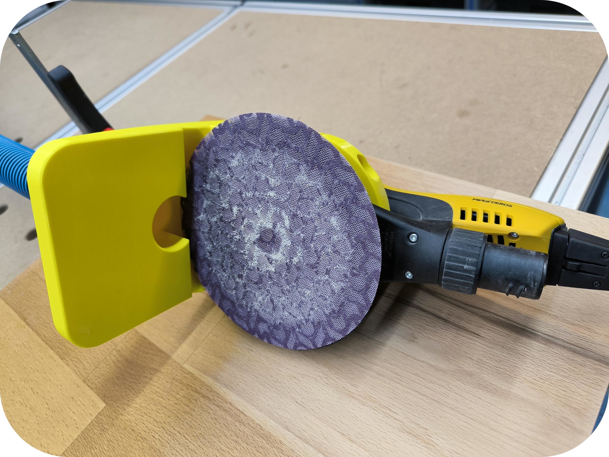 Flansch mit MIRKA DEROS in Gelb mit Sicht auf Schleifmittel